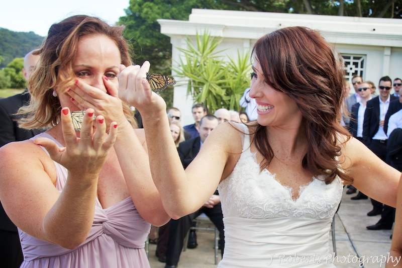 Bride and her sister crying during buffer fly release ceremony - wedding photography sydney